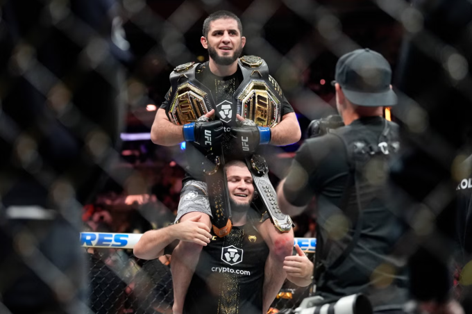 Khabib Nurmagomedov nâng Islam Makhachev mừng hai đai vô địch UFC. Ảnh: AP