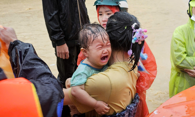 Em nhỏ bật khóc khi được cứu hộ qua vùng ngập trên đường 23 Tháng 10, phường Tây Nha Trang, ngày 20/11. Ảnh: Bùi Toàn