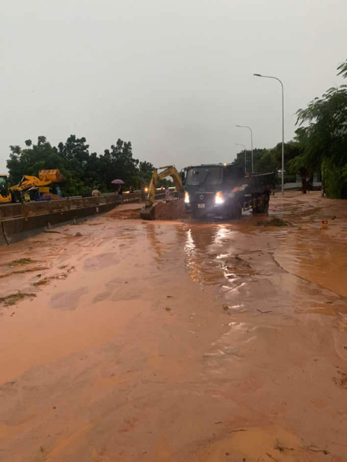 Xe mú, xe ben đang xử lý di chuyển cát đỏ ra khỏi quốc lộ 1. Ảnh: khải Nguyên