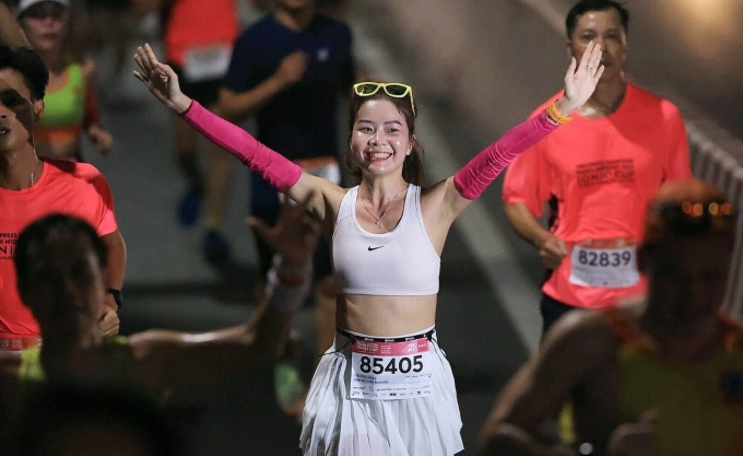 Nữ runner vẫy tay chào ống kính trên đường chạy VnExpress Marathon Hanoi Midnight 2023. Ảnh: VnExpress Marathon