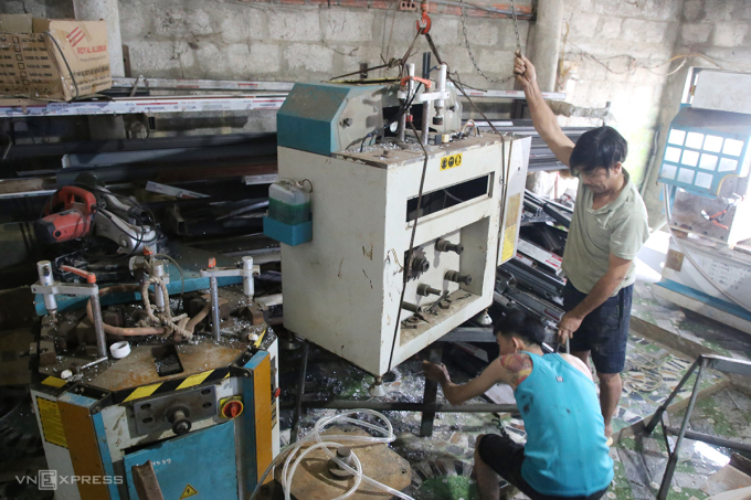 Hai cha con ông Thắng dùng ròng rọc đưa máy móc lên cao tránh lũ. Ảnh: Đắc Thành