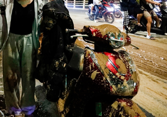 Xe và người dính bùn rơi xuống từ xe vật liệu. Ảnh: Đức Minh