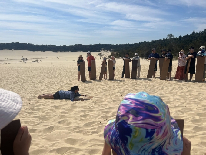 Du khách lắng nghe hướng dẫn viên hướng dẫn trượt cát tại khu vực đồi cát tại Tangalooma. Ảnh: Phương Anh