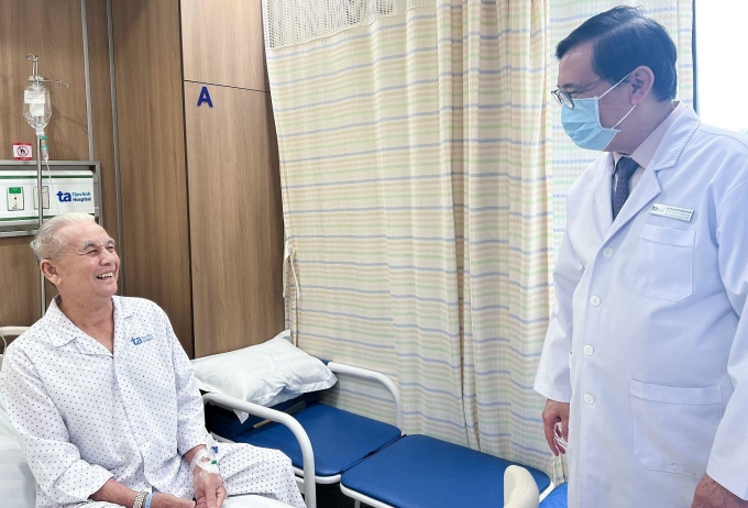 Giáo sư Nhân hỏi thăm sức khỏe ông Quýnh vào ngày thứ hai sau can thiệp. Ảnh: Minh Huyền