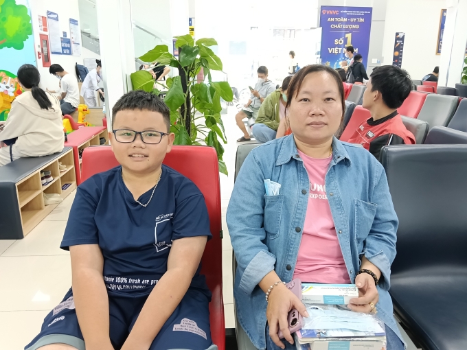 Mẹ con chị Hoàng Anh đi tiêm ngừa tại VNVC Tân Thuận. Ảnh: Hoàng Dương