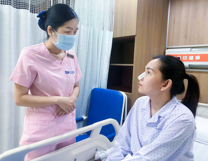 Nhân viên y tế hướng dẫn cách chăm sóc vết mổ cho chị Huyền. Ảnh: Bệnh viện cung cấp