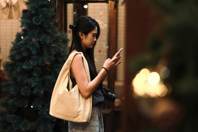 Một cô gái đang lướt mạng khi đi dạo phố. Ảnh minh họa: Trường Nguyễn Thanh