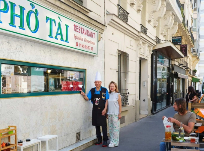 Vợ chồng chủ quán bên ngoài quán phở. Ảnh:Financial Times