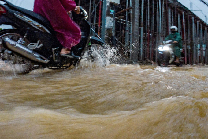 Tuyến đường Âu Cơ bị ngập, nước chảy siết do địa hình dốc. Ảnh: Ngọc Trường