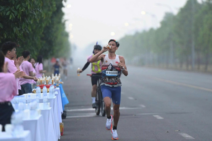 Nguyễn Văn Lai - á quân mùa một sử dụng nước ở trạm hỗ trợ. Ảnh: VnExpress Marathon
